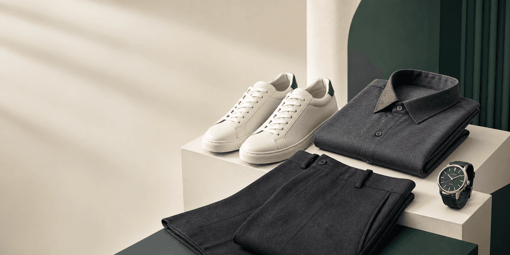 A curated fashion collection with white sneakers, a charcoal shirt, tailored pants, and a wristwatch